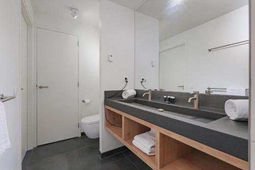 a bathroom with a sink and a toilet at Dune & Lakeview Villa 6p - Luxe, Lounge & Verwarmd Terras - Villa 30 in Ouddorp