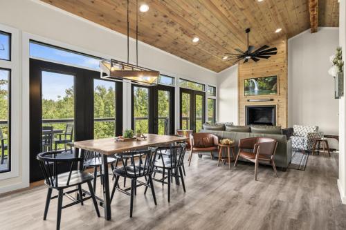 ein Esszimmer und ein Wohnzimmer mit Tisch und Stühlen in der Unterkunft Luxury Hot-Tub WiFi - A Red River Barnhouse in Campton