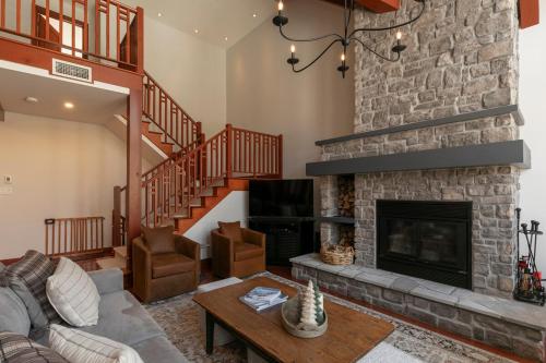 a living room with a fireplace and a couch at Deluxe Ski in-out - HotTub - Fire - PingPong - View in Mont-Tremblant