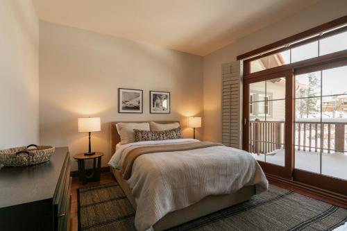 a bedroom with a bed and a large window at Deluxe Ski in-out - HotTub - Fire - PingPong - View in Mont-Tremblant