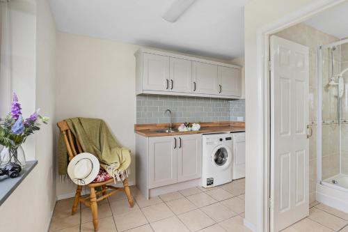 a kitchen with a sink and a washing machine at Rose Cottage in Port Isaac
