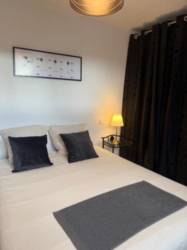 a bedroom with a large white bed with black curtains at Ti ponch in Mont-de-Marsan