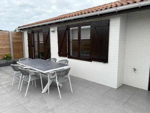 een tafel en stoelen op een terras bij Vakantiehuisje Wenduine in De Haan