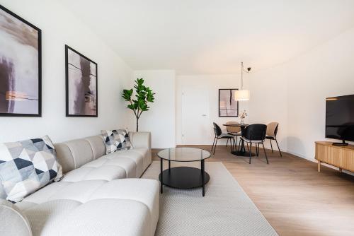 a living room with a white couch and a table at GOLD-APARTMENT 2 !Gratis Parken, Free Parking! in Frauenfeld
