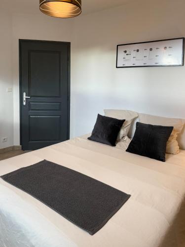 a bedroom with a large bed with a black door at Ti ponch in Mont-de-Marsan