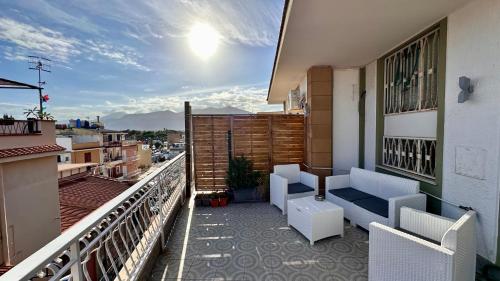 a balcony with a couch and chairs on a building at Mondello SunSea House in Mondello