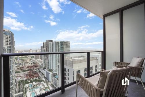 a balcony with two chairs and a view of the city at Stylish Apartments with Partial Ocean Views in Downtown! in Miami