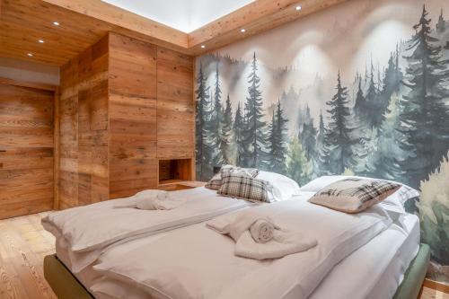 ein Schlafzimmer mit einem großen Bett mit einem Waldwandbild an der Wand in der Unterkunft BRENTA ALTA ALPINE LODGE MhD in Madonna di Campiglio