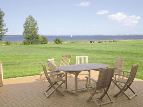 a picnic table and chairs with a view of a field at Ferienhaus "Lachmöwe" in Vaschvitz