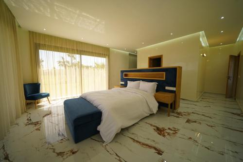 ein Schlafzimmer mit einem großen Bett und einem großen Fenster in der Unterkunft Villa Royal Paradise - Pool, Football, Tennis, Cinema in Sidi Bibi