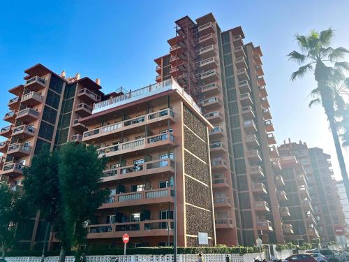 een hoog gebouw met twee palmbomen ervoor bij Sunrise Serenity in Puerto de la Cruz in Puerto de la Cruz