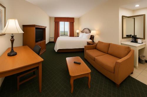 um quarto de hotel com uma cama e um sofá em Holiday Inn Port St. Lucie by IHG em Port Saint Lucie