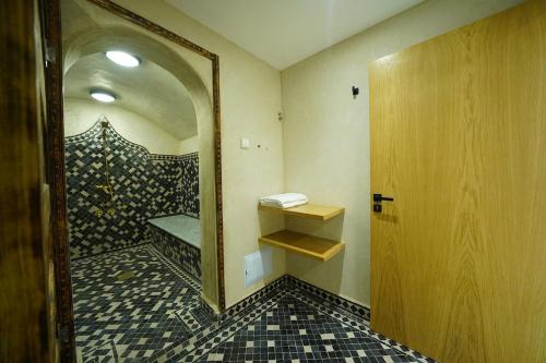 ein Badezimmer mit Spiegel und Fliesenboden in der Unterkunft Villa Royal Paradise - Pool, Football, Tennis, Cinema in Sidi Bibi