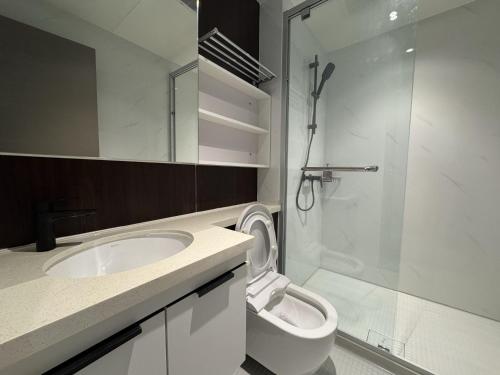Un baño con inodoro, lavabo y ducha. en Bay Suites l Seaview l 8 Pax l SICC l 沙巴全海景民宿, en Kota Kinabalu
