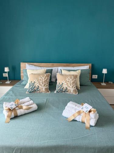a bed with two towels on it with a blue wall at Di Michi in Torre del Greco