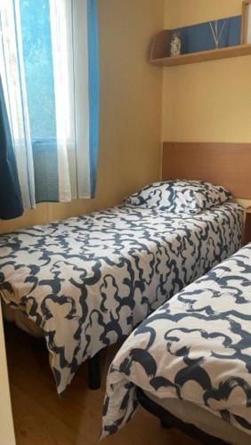 two beds sitting next to each other in a bedroom at Mobilhome 6 personnes in Hyères