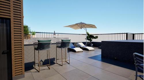 a patio with a table and chairs and an umbrella at The Astor - All Suites Hotel Candolim Goa in Candolim