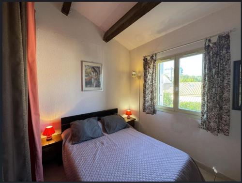 une chambre avec un lit et une fenêtre dans l'établissement Gîte Méditérranée, à Argelès-sur-Mer