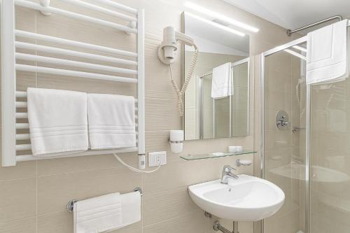 a white bathroom with a sink and a shower at Hotiday La Spezia Centrale in La Spezia