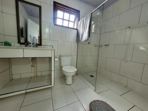 Un baño con inodoro y ducha de cristal. en Espaço Villa dos Anjos, en Morretes