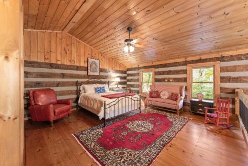 a bedroom with a bed and a couch and a chair at Cabin Chateau- Modern Escape with Outdoor Living area with Fireplace & Hot Tub in Baldwin