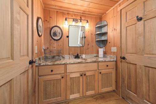 a bathroom with a sink and a mirror at Cabin Chateau- Modern Escape with Outdoor Living area with Fireplace & Hot Tub in Baldwin