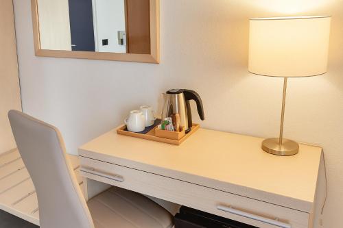 a desk with a lamp and a tea kettle on it at Hotiday La Spezia Centrale in La Spezia