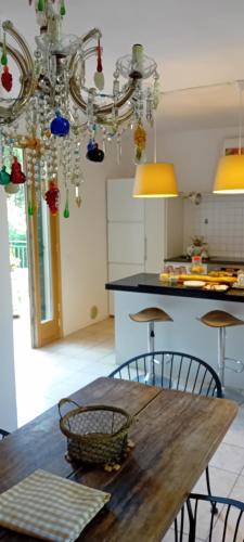 cocina con mesa con sillas y lámpara de araña en Villa Riviera Naviglio Venezia, en Vigonovo