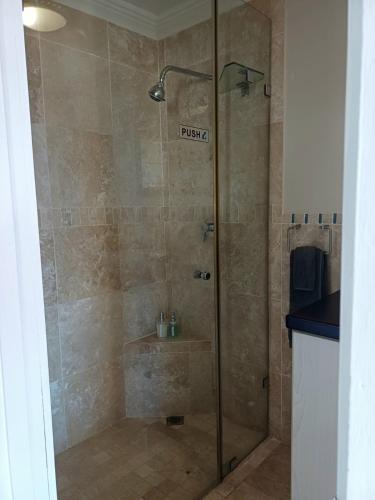 a shower with a glass door in a bathroom at Eagle's Nest in Mossel Bay