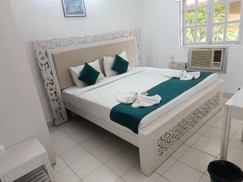 a bedroom with a white bed with two towels on it at Candolim apartment in Candolim