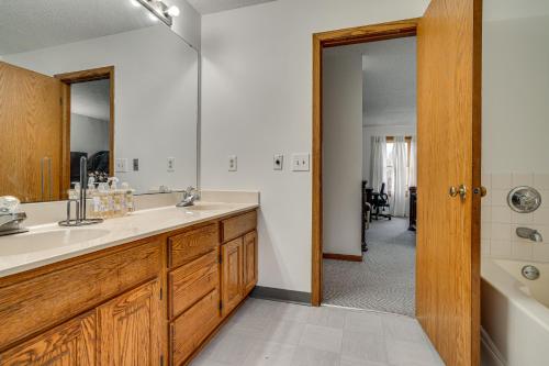 a bathroom with a sink and a mirror and a tub at 12 Mi to Dtwn St Paul Extended Stay in Woodbury! in Woodbury