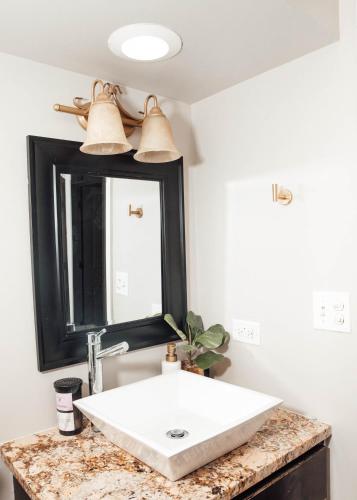 a bathroom with a white sink and a mirror at Modern & Spacious Stay by Northwestern Hospital Bronzeville in Chicago