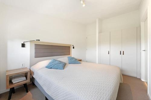 奥德多普Studio Waterfront | 2 Pers.的卧室里有一张白色的大床，配有蓝色的枕头