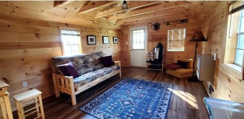 a living room with a couch in a log cabin at Off-Grid Cabin Nestled Among Nature with Lovely Landscape Views in Maine in Lavertue