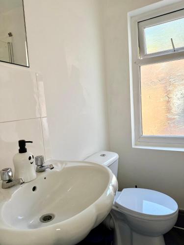 a white bathroom with a sink and a toilet at The Quite Resort in Birmingham