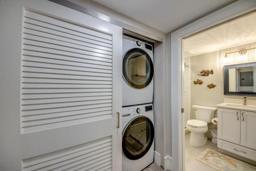 a bathroom with a washer and dryer next to a toilet at Sand Pointe 137 in Sanibel