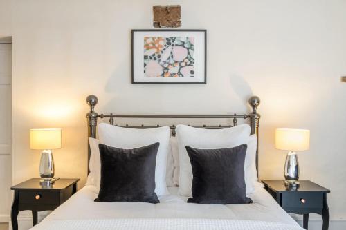 a bedroom with a bed with two lamps on tables at Dovecote Farmhouse in West Leake