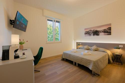 a bedroom with a bed and a desk with a computer at Camera Helsinki - La Casa di Carta Affittacamere in Udine