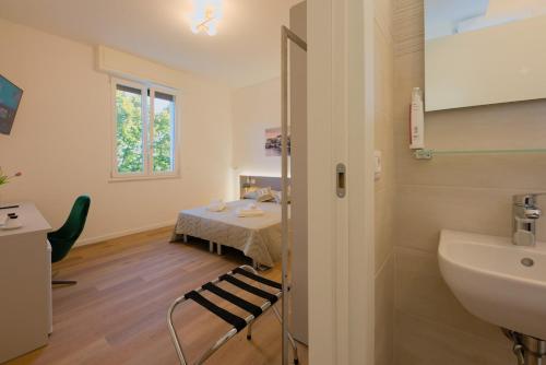 a bathroom with a sink and a table in a room at Camera Helsinki - La Casa di Carta Affittacamere in Udine