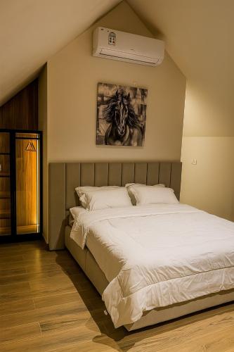 a bedroom with a large white bed in it at ستاي إن Stay Inn in Ma‘mad