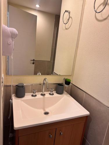 a bathroom with a sink and a mirror at Suite del Sol 106 in Pinamar