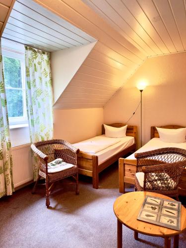 a room with two beds and a table and chairs at Pension an der Dolzke in Kaupen