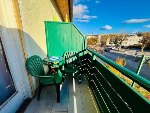 a balcony with two chairs and a table on it at Pension am Campus Velden in Velden am Wörthersee
