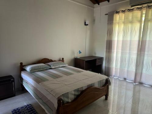 Un dormitorio con una cama y una ventana con cortinas. en Bamboo Tree Villa, 