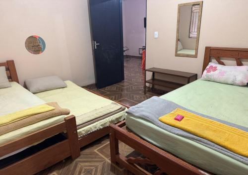 a room with two twin beds and a mirror at Casa Laranja in Presidente Figueiredo