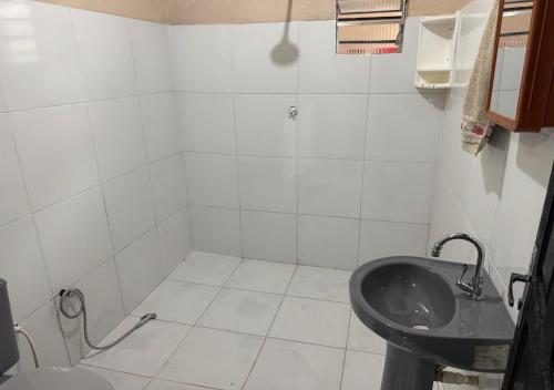 a white bathroom with a sink and a toilet at Casa Laranja in Presidente Figueiredo