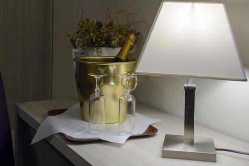 a table with a lamp and a bucket with a champagne bottle at Hotel Torino Porta Susa in Turin