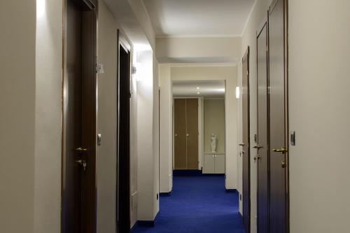 a hallway with white doors and a blue carpet at Hotel Torino Porta Susa in Turin