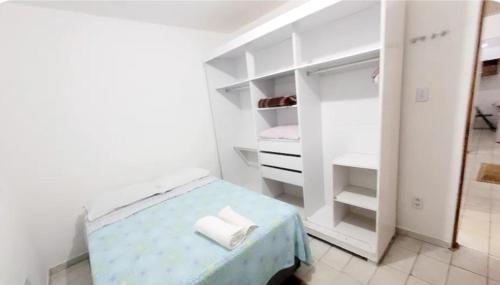 a small white room with a bed and a closet at Casa Aeroporto a poucos minutos do Aeroporto de Viracopos in Campinas