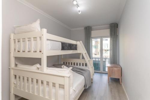 a white bedroom with a bunk bed and a window at BeGuest Jardim Quinta da Alagoa Luxury Stay in Carcavelos